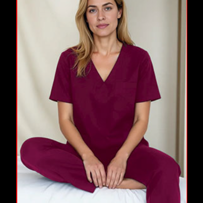 Mulher sentada numa cama vestindo pijama bordô com decote em V.