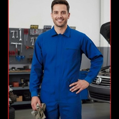 Homem com macacão azul numa oficina automóvel, segurando um pano cinza