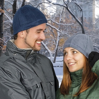 Homem e mulher com gorros de lã e casacos acolchoados num parque nevado