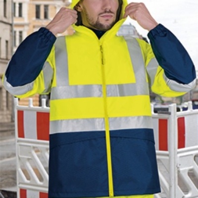 Homem com casaco impermeável amarelo e azul com faixas refletoras e capuz amarelo