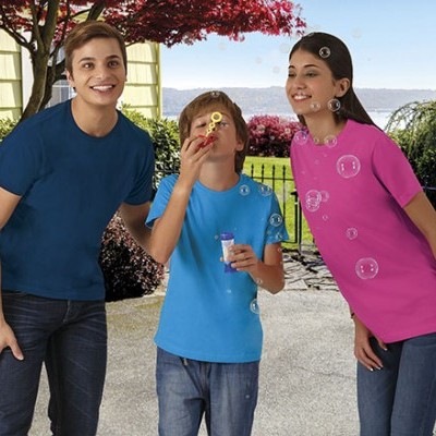 Três pessoas ao ar livre com t-shirts coloridas e bolhas de sabão.