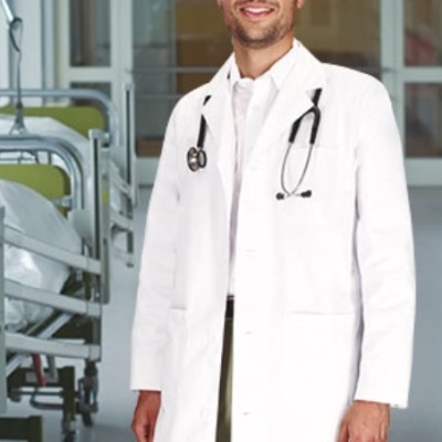 Médico com bata branca e estetoscópio ao pescoço em hospital.