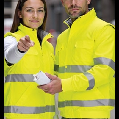 Homem e mulher com coletes amarelos de alta visibilidade e faixas refletoras na rua