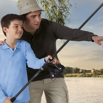 Um homem e uma criança pescando juntos ao lado de um lago