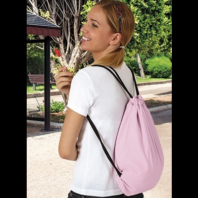 Mochila saco rosa claro com cordões pretos usada por jovem em jardim