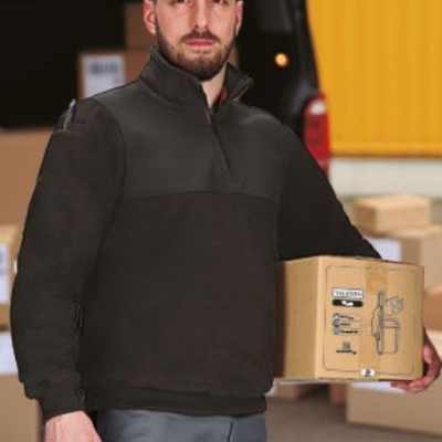 Homem com blusão preto segurando caixa de cartão com texto VISIBILITY e desenho técnico