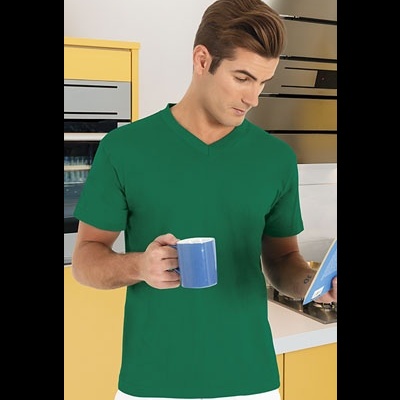 Homem com t-shirt verde segurando caneca azul e lendo livro