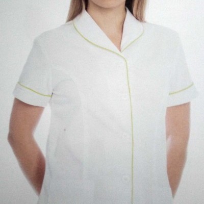 Veste branca com detalhes verdes usada por mulher em fundo neutro