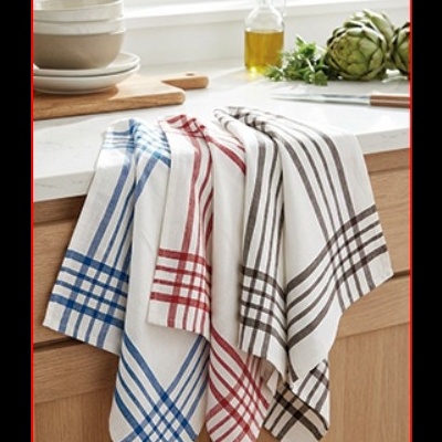 Quatro panos de cozinha com riscas coloridas pendurados numa bancada