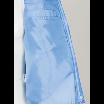 Interior de casaco azul claro com bolso e fecho de velcro.