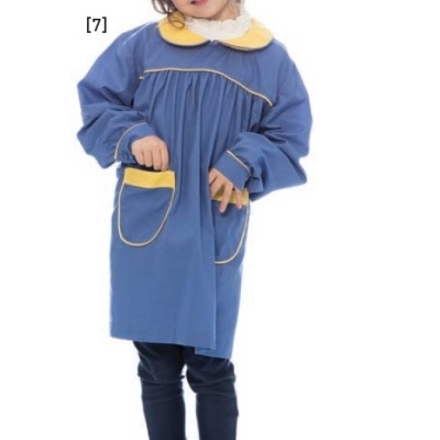 Criança vestindo bata escolar azul com detalhes amarelos e calças escuras