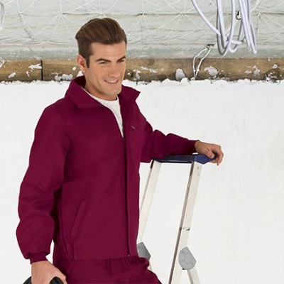 Homem com fato de trabalho bordeaux encostado numa escada metálica junto à neve