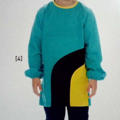 Criança com chapéu, bata colorida, calças escuras e ténis azuis