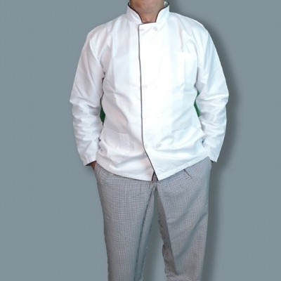 Homem com bata de chef branca e calças xadrez cinza em fundo cinzento.