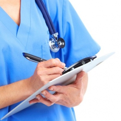 Profissional de saúde em uniforme azul com estetoscópio e prancheta