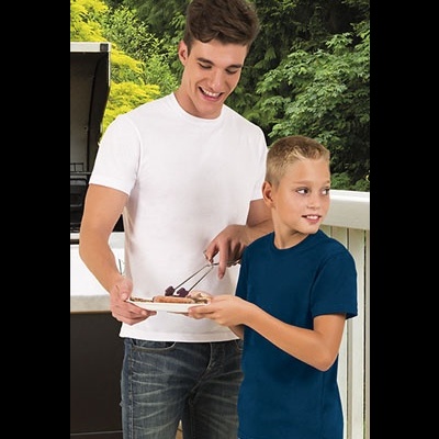 Dois rapazes com t-shirts branca e azul junto a churrasqueira numa varanda com árvores ao fundo.