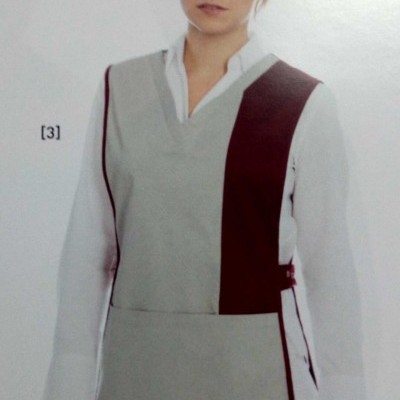 Colete cinzento claro com pormenores vinho e decote em V sobre camisa branca.