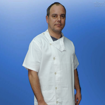Homem de bata branca de botões com calça preta e tênis em fundo azul