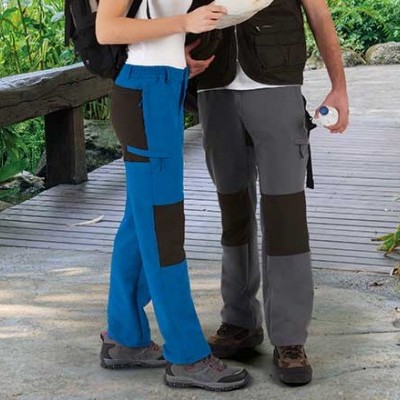 Calças outdoor coloridas com painéis contrastantes em cenário natural