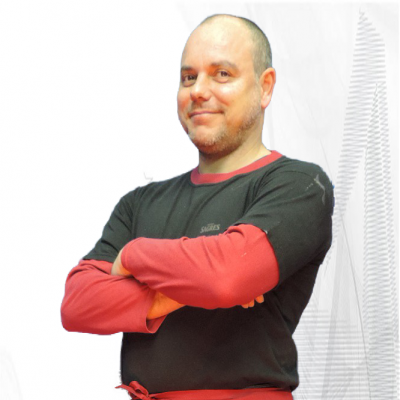 Homem vestindo avental vermelho, camisa vermelha, t-shirt preta e calças de ganga