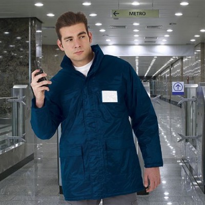 Homem com parka azul escura numa estação de metro