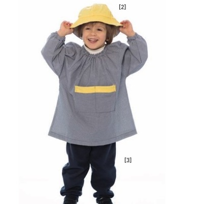 Criança com bata cinzenta, bolso amarelo, calças azul escuro, sapatos pretos e chapéu amarelo