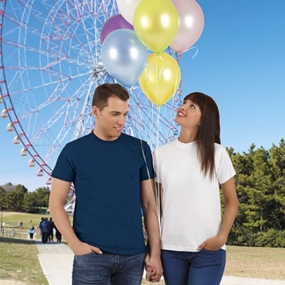 Homem e mulher com t-shirts simples e balões coloridos num parque com roda gigante ao fundo