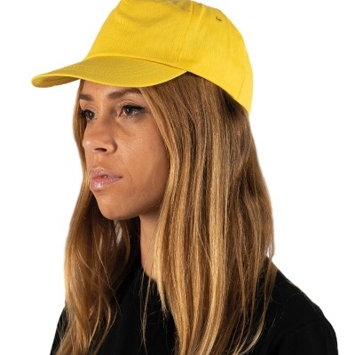Boné amarelo em tecido usado por mulher com cabelo comprido