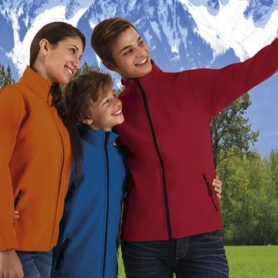 Grupo de três pessoas com casacos coloridos a tirar selfie em ambiente natural