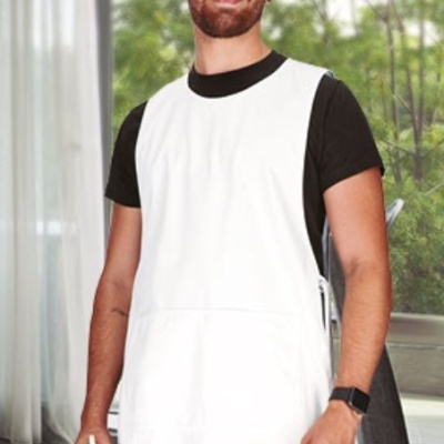 Homem com avental branco sobre t-shirt preta segurando garrafa amarela em interior com plantas