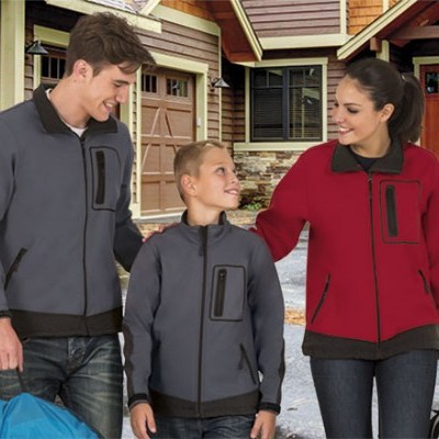 Três pessoas com casacos fleece de zíper cinza e vermelho em frente a casa com garagem