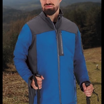 Homem com casaco azul e cinza segurando bastões de caminhada em ambiente montanhoso