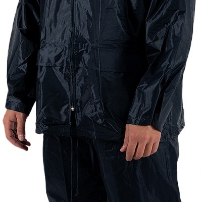 Homem com fato de treino impermeável preto e ténis cinzentos em fundo branco