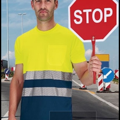 Homem com roupa de sinalização amarela e faixa reflexiva a segurar placa STOP vermelha