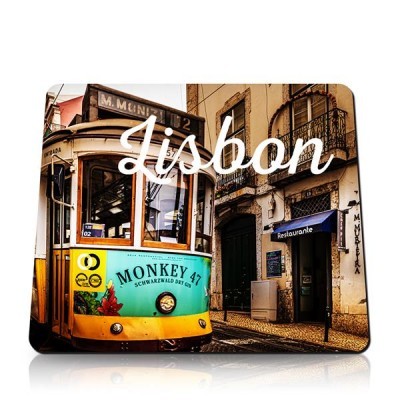 Elétrico amarelo com anúncio Monkey 47 em frente a edifício com restaurante em Lisboa