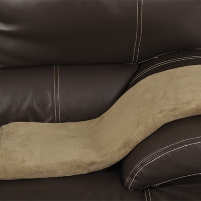 Almofada castanha clara sobre sofá de couro castanho escuro
