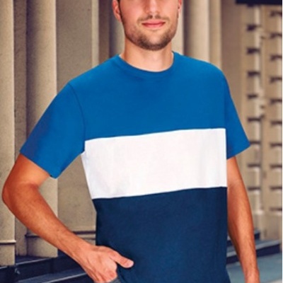 Homem com camisola às riscas azul claro, branco e azul escuro num cenário urbano com colunas.