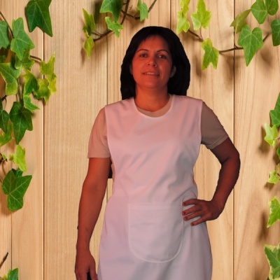 Mulher com avental branco e t-shirt bege frente a fundo de madeira com folhas verdes