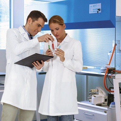 Dois cientistas com batas brancas a analisar tubos de ensaio num laboratório