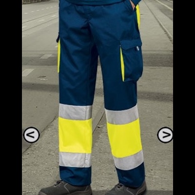 Calças de trabalho azuis com detalhes amarelos fluorescentes e faixas refletoras cinza, usadas com calçado de segurança.