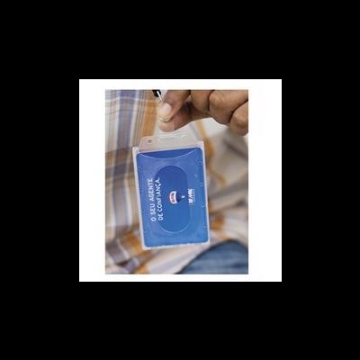 Cartão de identificação azul com texto, segurado em suporte transparente por uma mão.
