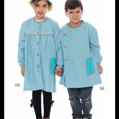 Duas crianças com batas escolares azuis e chapéus, em fundo branco.