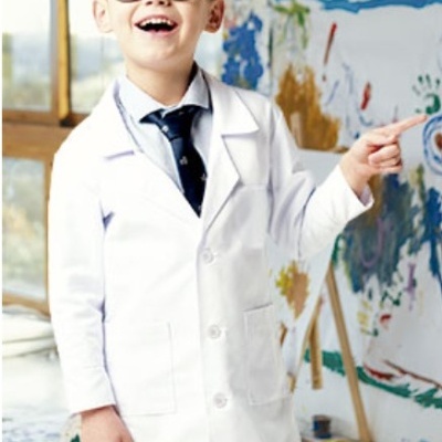 Criança com bata branca de laboratório e óculos em ambiente artístico colorido
