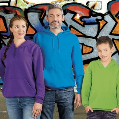 Três pessoas com sweatshirts coloridas em frente a parede grafitada