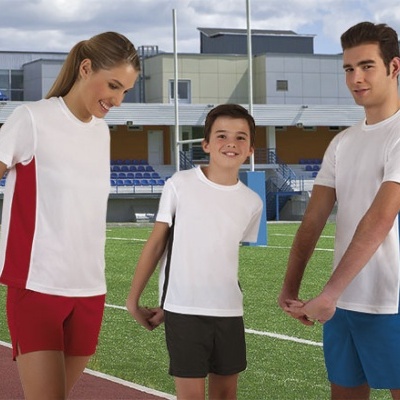 Três pessoas de roupa desportiva em campo de atletismo.