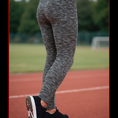 Leggings cinzentas mescladas e sapatilhas pretas numa pista de atletismo