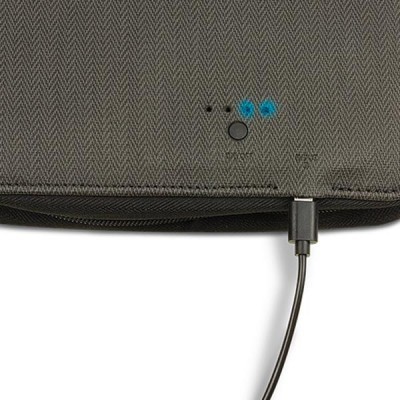 Bolsa cinza com padrão chevron, botão e LEDs azuis, cabo USB ligado.