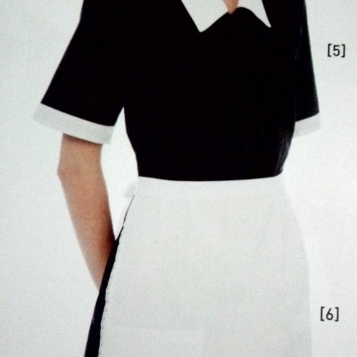 Modelo a usar vestido preto com gola e punhos brancos e avental branco.