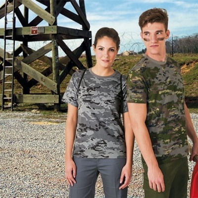 Duas pessoas com t-shirts camufladas, estrutura de madeira e paisagem exterior