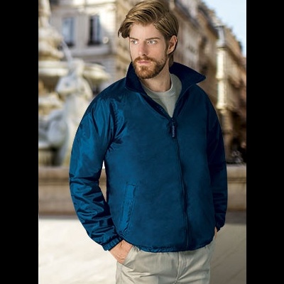 Homem vestido com casaco azul escuro em ambiente urbano ao ar livre